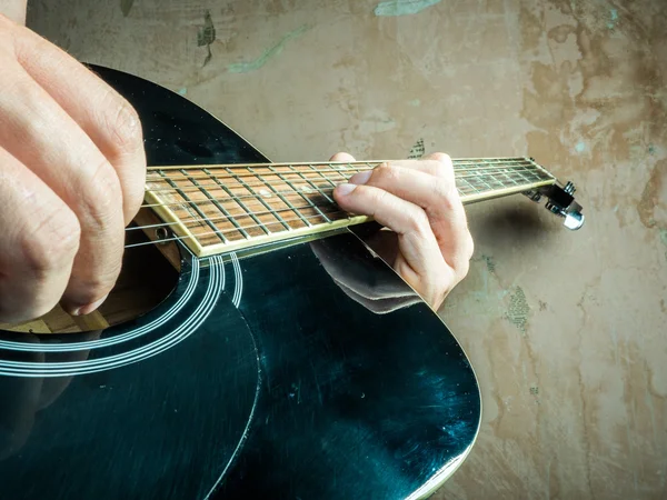 Foto de primer plano de una guitarra acústica tocada por un hombre . — Foto de Stock