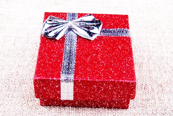 Red gift box on canvas — Stock Photo, Image