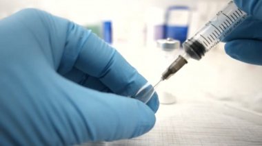Kadın doctorfemale doktor dikkatle iğne hazırlanıyor