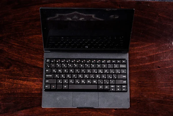 Laptop preto em madeira — Fotografia de Stock