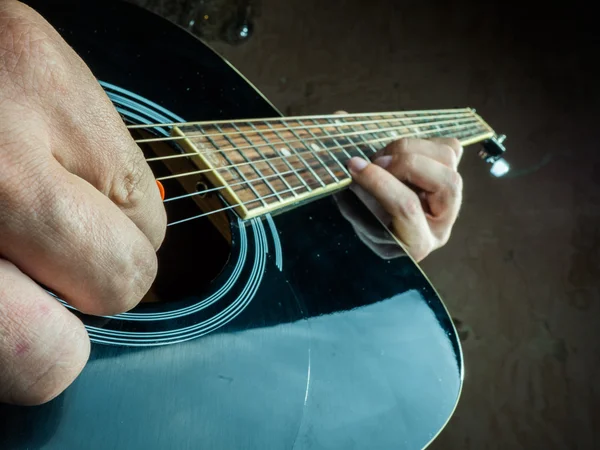 Foto de primer plano de una guitarra acústica tocada por un hombre . —  Fotos de Stock