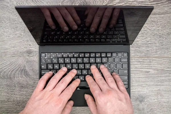 Laptop com as mãos em madeira — Fotografia de Stock