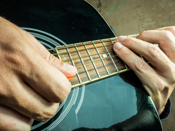 Foto de primer plano de una guitarra acústica tocada por un hombre . — Foto de Stock