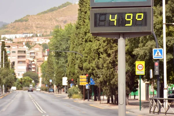 Street thermometer on a street marking 49 degrees celsius in summer