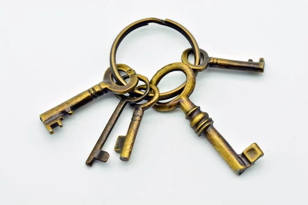 Detail of a key ring with several old metal keys, isolated on white background