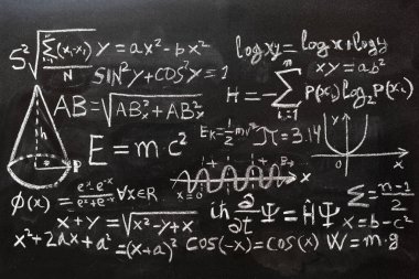 Matematiksel işlemler ve kuantum fiziği formülleri tahtaya tebeşirle yazılmış.