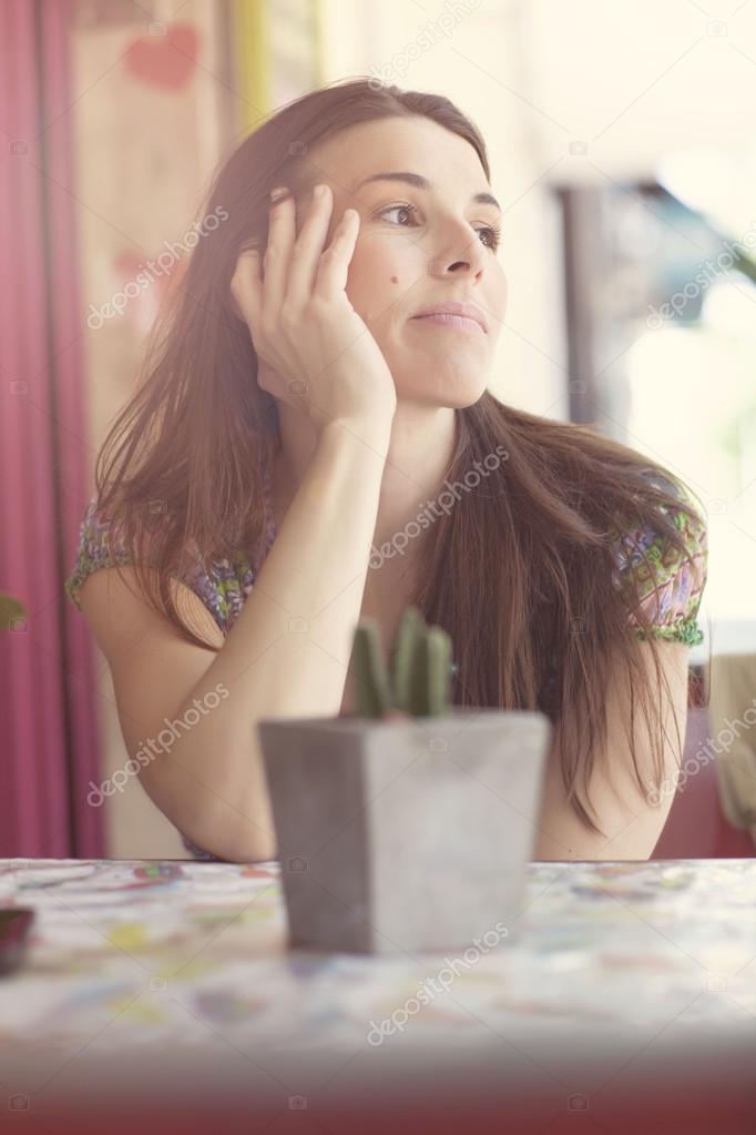 Young latin woman at street bar worried