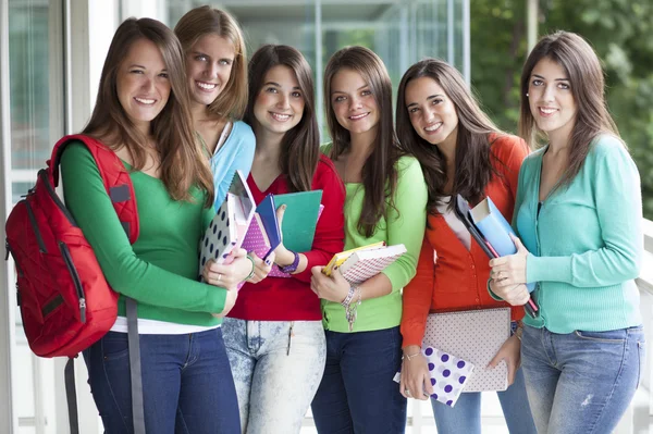 Adolescentes sonrientes con libros de ejercicios — Foto de Stock