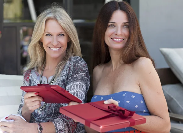 Hermosas mujeres de mediana edad con regalos sentados al aire libre — Foto de Stock