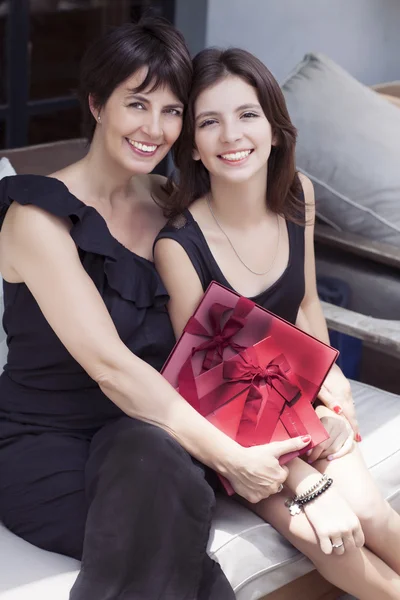 Mère et fille avec des cadeaux assis à l'extérieur — Photo