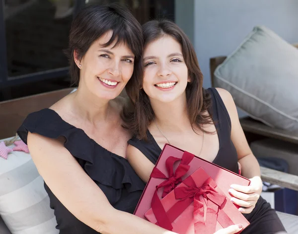 Mãe e filha com presentes sentados ao ar livre — Fotografia de Stock