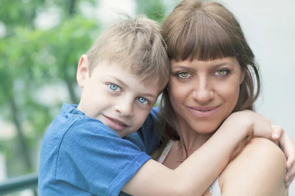 Porträt eines entzückenden Jungen, der ihre Mutter umarmt — Stockfoto