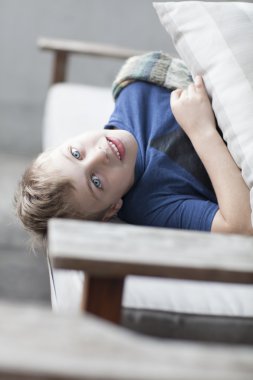 Tembel komik küçük çocuk koltukta yalan