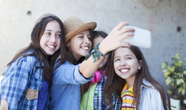 Mutlu arkadaş bir akıllı telefon ile fotoğraf çekmek açık portresi