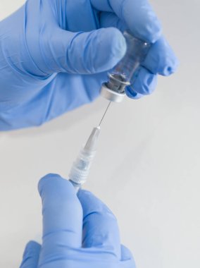 Mavi Plastik Eldivenler 'de Tıbbi Şırınga ve Beyaz Arkaplan' da Vial Kapanış