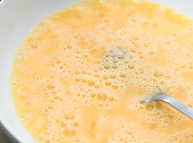 Çatallı, beyaz tabakta çırpılmış yumurta.