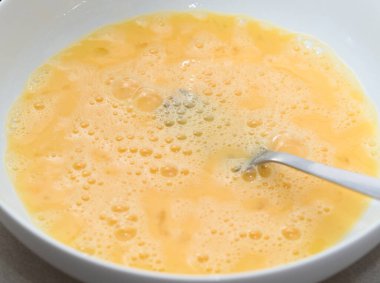 Çatallı, beyaz tabakta çırpılmış yumurta.