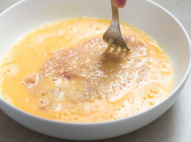 Yenilmiş yumurtalara çatallı domuz eti batırma.