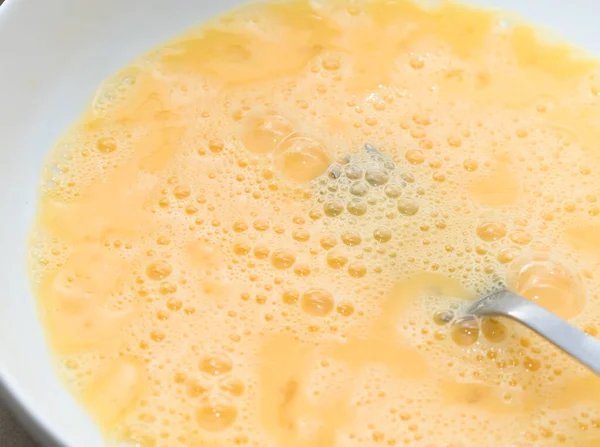 Çatallı, beyaz tabakta çırpılmış yumurta.