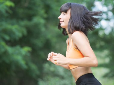 Dışarıda egzersiz yapan güzel, sıska bir kadın.