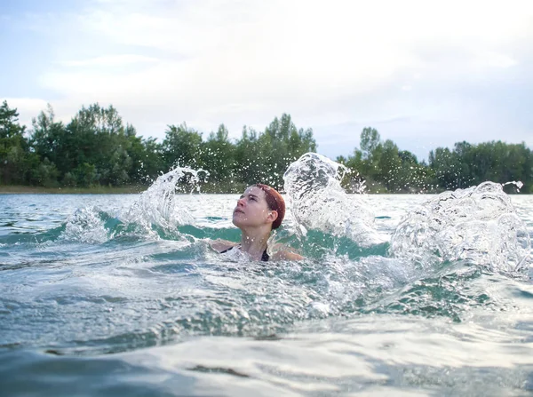 赤い髪の若い女性が水をスプラッシング — ストック写真