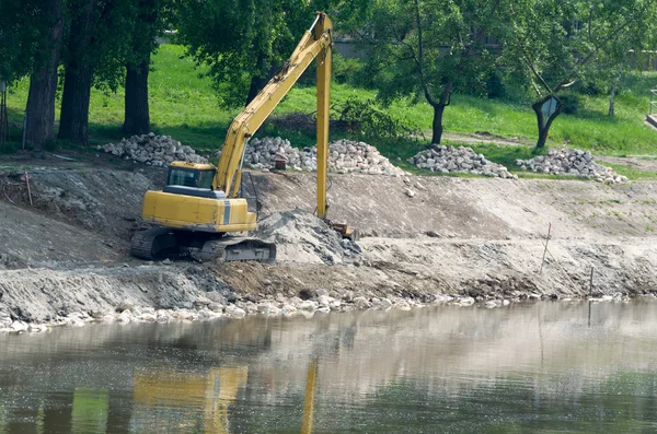 黄色挖掘机在河岸 — 图库照片