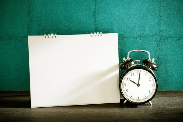 Standbild eines Schreibtischkalenders mit Wecker auf einem Holztisch. Vintag — Stockfoto