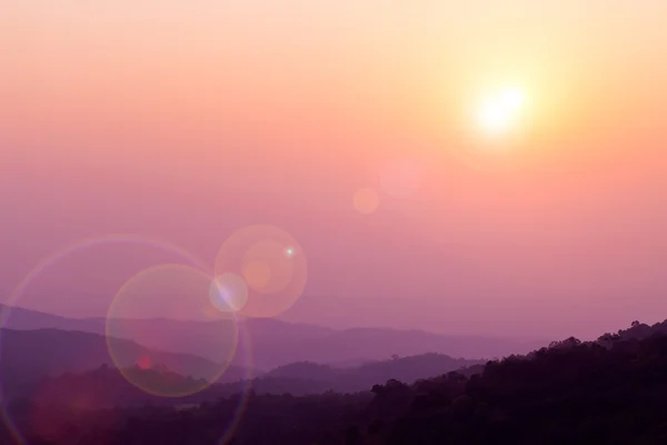 Beautiful sunset sky with flare at mountain. — Stock Photo, Image