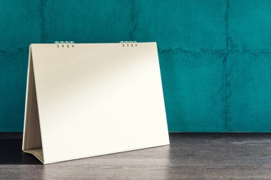 Yeşil duvar arka plan üzerinde boş masa takvimi.