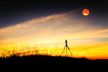 Tripod stand aya ile dağ güneş battıktan sonra.