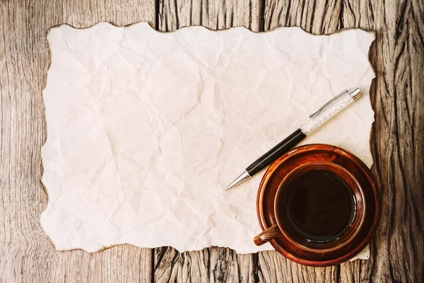Üres égett papír, toll, és a kávé csésze a régi fa asztal. — Stock Fotó