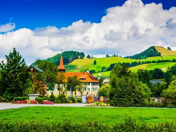 Дома в маленьком швейцарском городке с облаками и голубым небом в backgr — стоковое фото