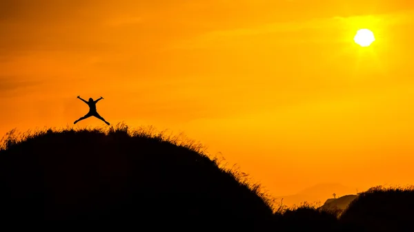 Silueta muže na vrcholu hory se západem slunce. Konceptuální scéna. — Stock fotografie