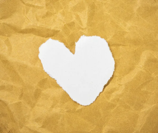 Forma de corazón en letras de revista recortadas puestas sobre papel marrón . — Foto de Stock