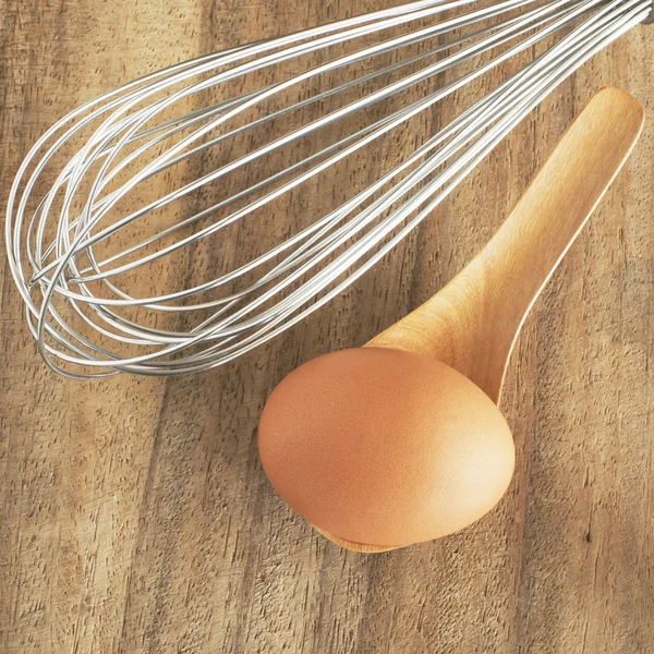 fresh brown eggs in wooden spoon on table.