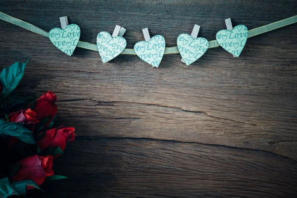 Valentine red roses with hearts on old wood background. — Stock Photo, Image