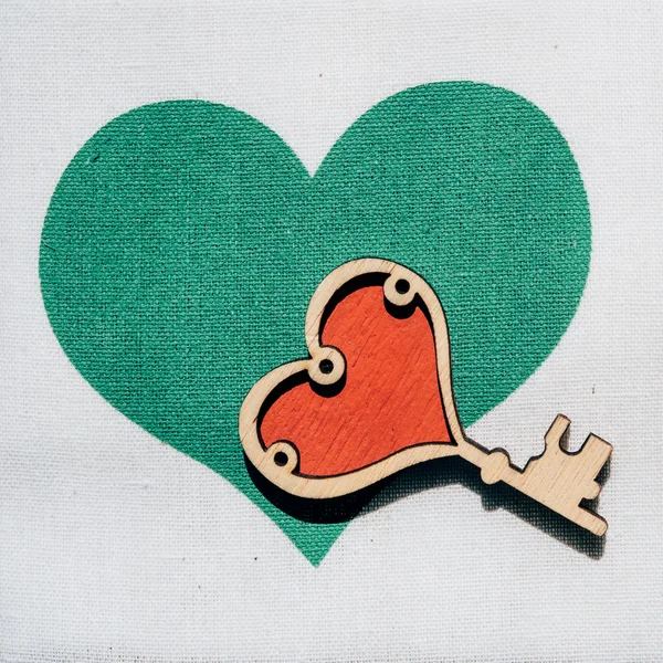 Coeur vert avec clé sur fond en bois . — Photo