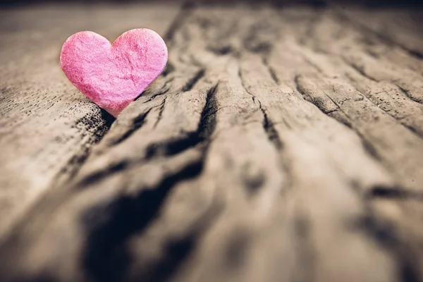Fondo del día de San Valentín con corazón rosa sobre pestaña de madera grunge — Foto de Stock