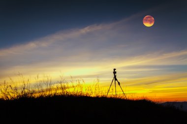 Tripod stand aya ile dağ güneş battıktan sonra.