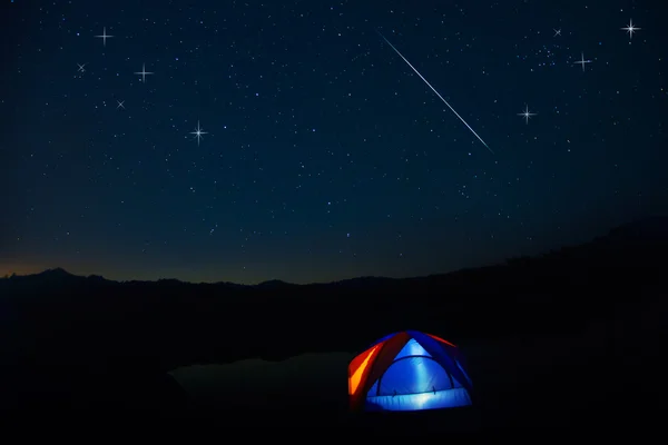 Tenda de acampamento sob estrelas à noite — Fotografia de Stock