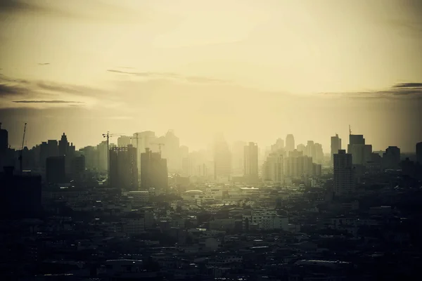 Hazy skyline of Bangkok City at dawn, smoke with sunrise.