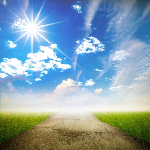 Расколотая асфальтовая дорога с солнечным лучом и голубым небом в сельской местности — стоковое фото