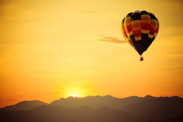 Hot air balloon flight over mountain with sunset. Royalty Free Stock Images