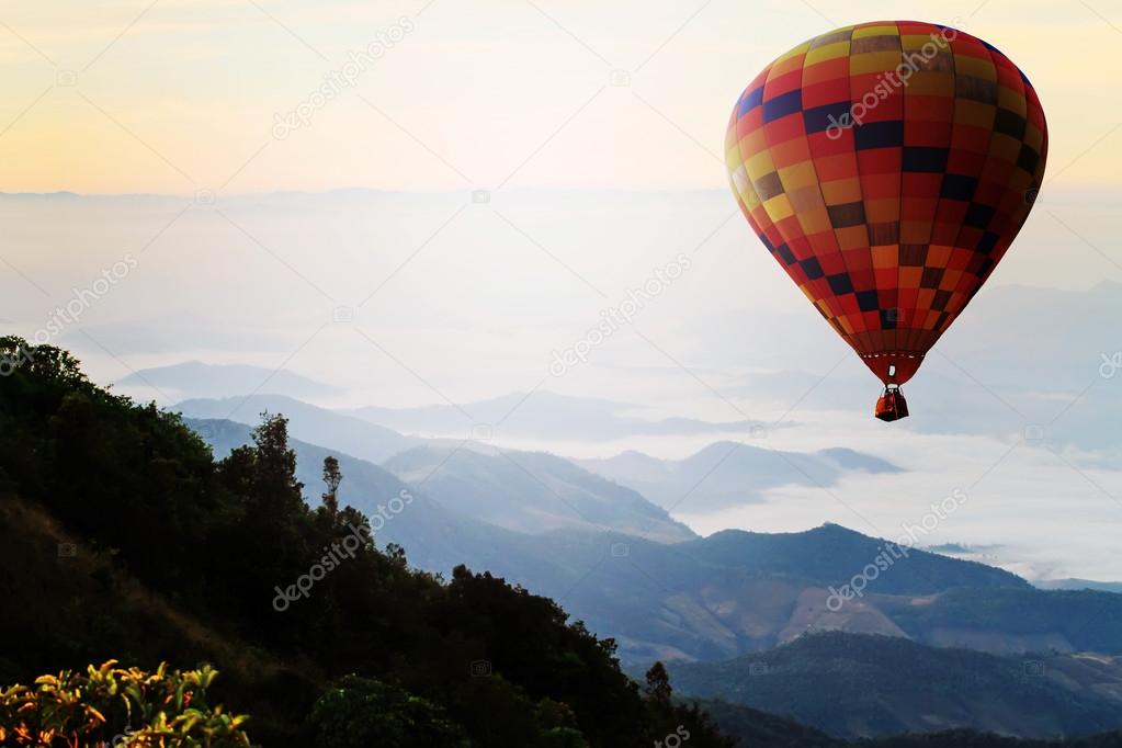 Hot air balloon over mountain in sunrise. Travel concept.