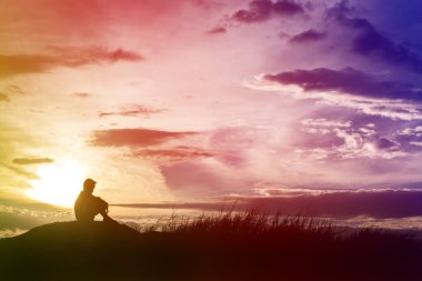 Üzgün çocuk siluet çayır on gün batımı, siluet kavramı endişeli.