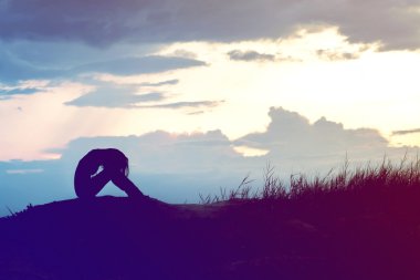 kadın siluet dağda günbatımında endişeli.