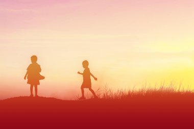 Siluet çocuklar gün batımında mutlu vakit geçiriyorlar. 
