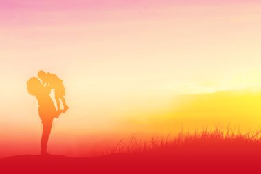 Anne oğlunu açık havada, günbatımı, siluet kavramı teşvik