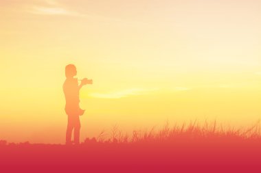 Siluet kadın fotoğrafçı gün batımında