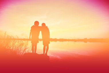 Siluet çocuklar gün batımında mutlu vakit geçiriyorlar. 